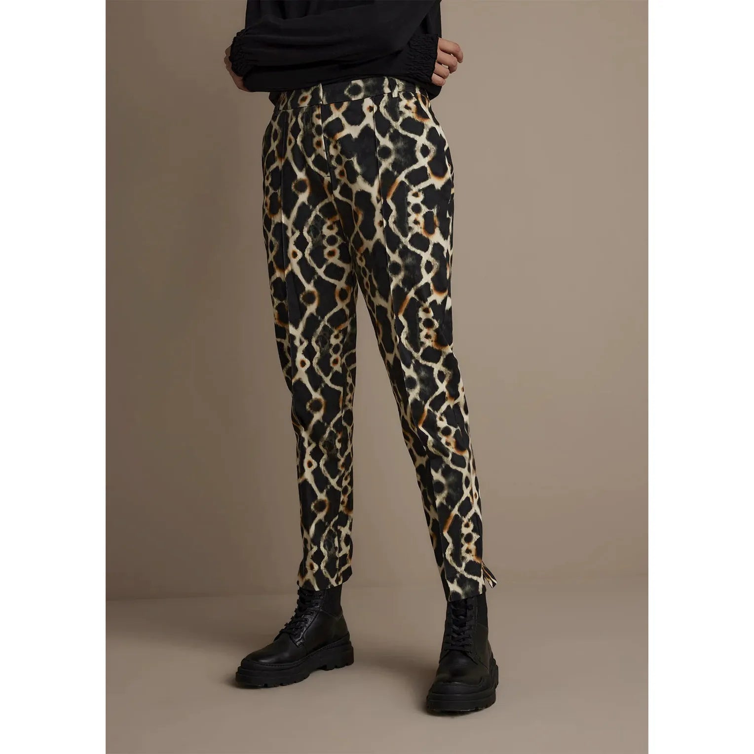 Figure-hugging trousers with small slits along the bottoms of the legs. The trousers are from a soft, stretchy cotton fabric and feature a tie-dye print. The jeans have slit pockets at the front and flap pockets at the back.